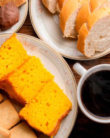 Bread and cake on a wooden table with a cup of coffee